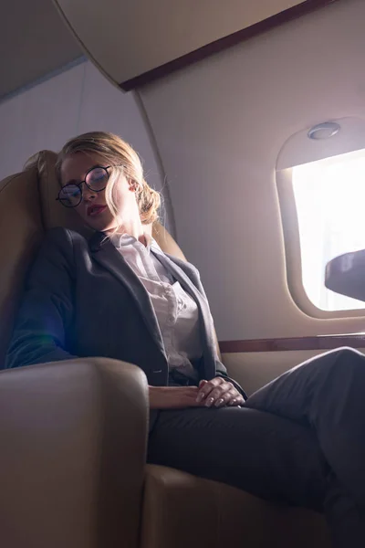 Atractiva mujer de negocios durmiendo en avión durante su viaje de negocios - foto de stock