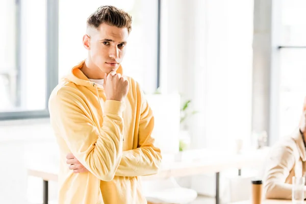 Guapo joven hombre de negocios en ropa casual mirando a la cámara - foto de stock