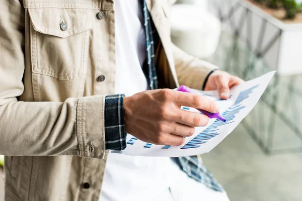 Vista recortada del empresario sosteniendo papel con gráficos y gráficos - foto de stock