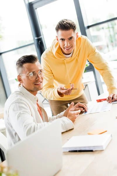 Young businesspeople smiling at camera while working together in office — Stock Photo