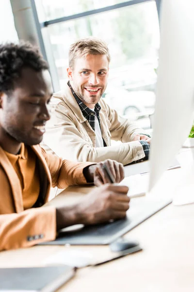 Selective focus of two multicultural businessmen working together in office — Stock Photo