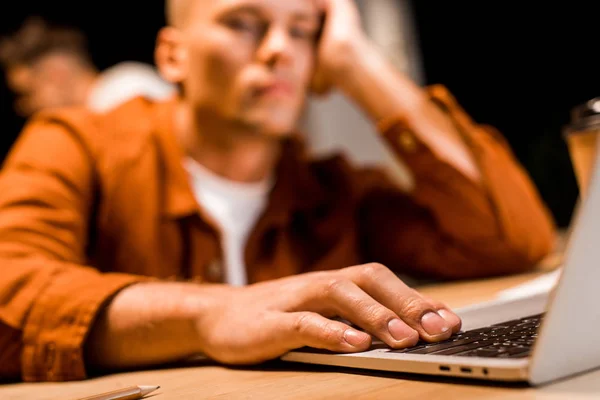 Enfoque selectivo de hombre de negocios agotado utilizando el ordenador portátil en la noche en la oficina - foto de stock