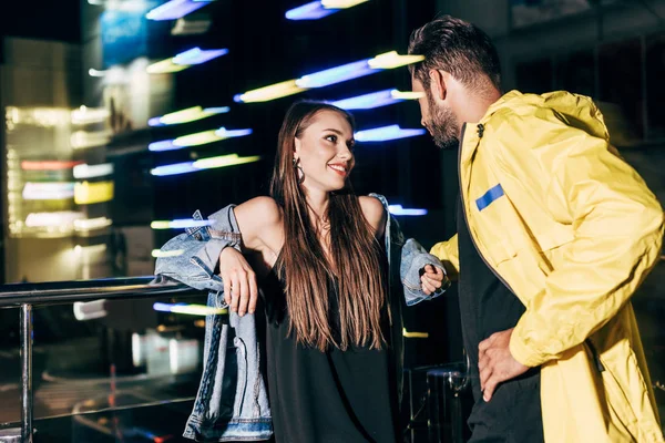 Sorridente fidanzata e fidanzato che parlano e si guardano in città di notte — Foto stock