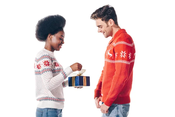 Щаслива міжрасова пара тримає подарунок Різдва, ізольована на білому — стокове фото