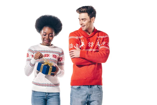 Beautiful interracial couple holding christmas present, isolated on white — Stock Photo