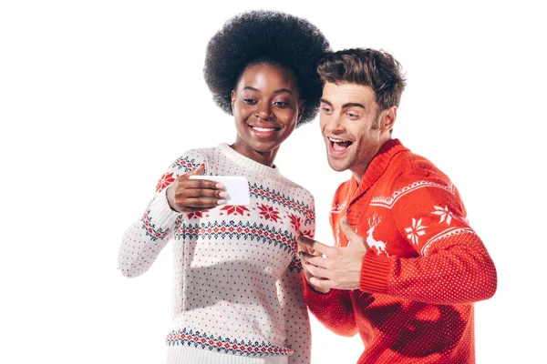 Hermosa pareja interracial feliz usando teléfono inteligente, aislado en blanco - foto de stock