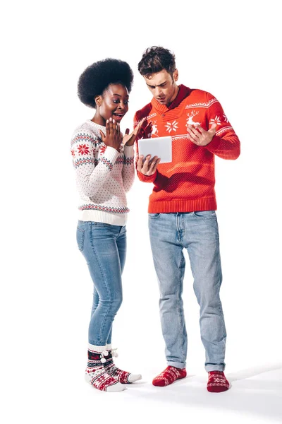 Feliz jovem casal interracial usando tablet digital, isolado em branco — Fotografia de Stock