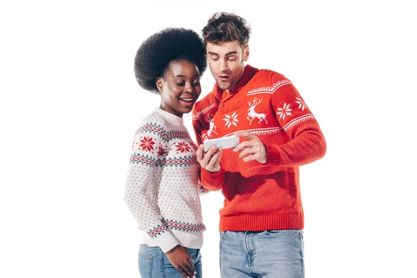 Smiling interracial couple using smartphone, isolated on white — Stock Photo