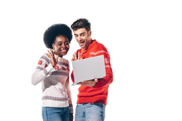 Couple multiculturel en chandails faire appel vidéo sur ordinateur portable, isolé sur blanc — Photo de stock