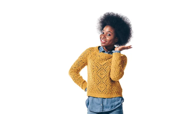 Linda menina americana africana em suéter amarelo mostrando seu cabelo encaracolado, isolado em branco — Fotografia de Stock