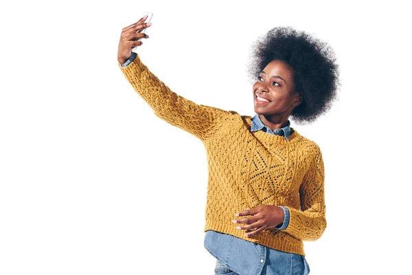 Beautiful african american girl taking selfie on smartphone, isolated on white — Stock Photo