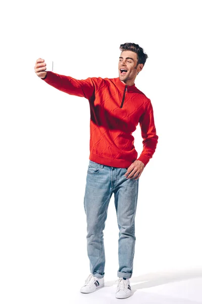Hombre excitado tomando selfie en el teléfono inteligente, aislado en blanco - foto de stock
