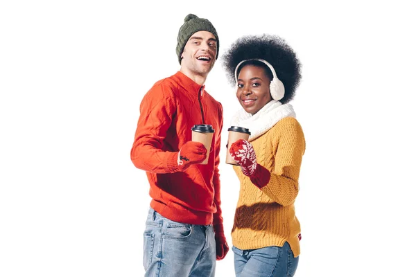 Sorridente coppia multietnica in abiti invernali in possesso di caffè per andare, isolato su bianco — Foto stock