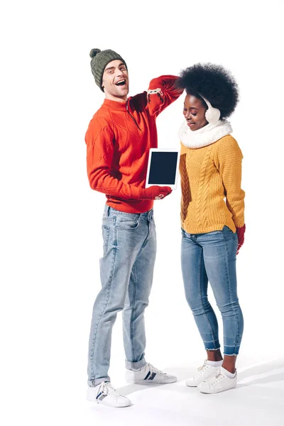 Beautiful multicultural couple pointing at digital tablet with blank screen, isolated on white — Stock Photo