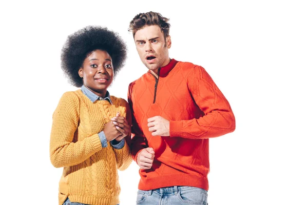Shocked multicultural couple in yellow and red sweaters, isolated on white — Stock Photo