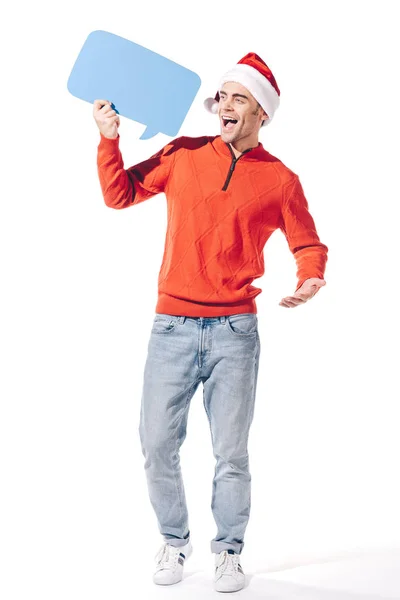 Возбужденный мужчина в шляпе санта, держащий синий пустой мыльный пузырь, изолированный на белом — стоковое фото