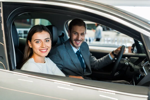 Foco seletivo de mulher bonita sentado no carro com o homem — Fotografia de Stock