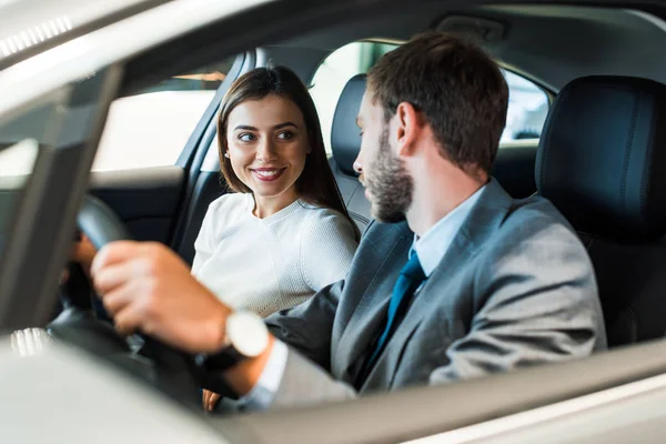 Selectivo, enfoque, de hombre barbudo conduciendo coche y mirando a la chica - foto de stock