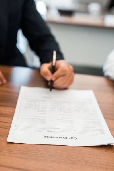 Orientation sélective de l'homme signant un contrat d'assurance automobile — Photo de stock
