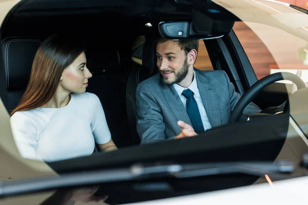Селективный фокус бородатого мужчины, смотрящего на женщину в машине — стоковое фото