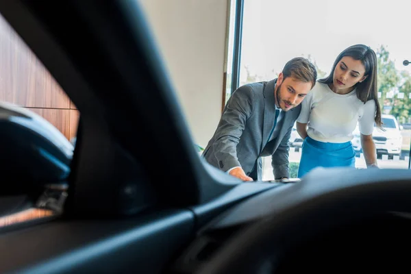 Selective focus of bearded man standing with woman and looking at car — Stock Photo