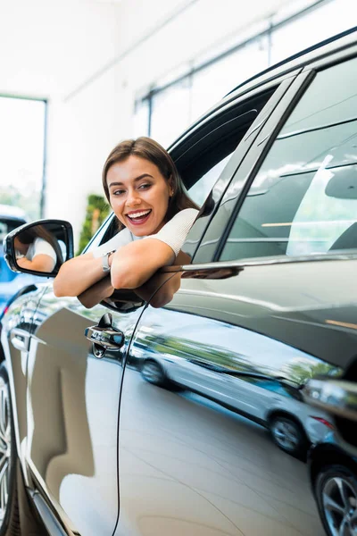 Selective focus of happy woman sitting in shiny car — Stock Photo