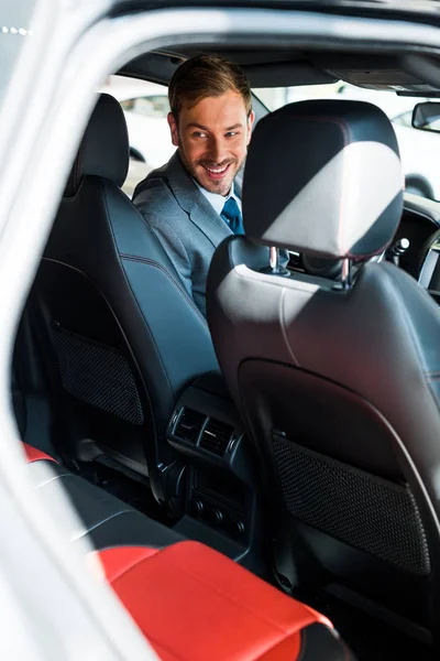 Selektiver Fokus des glücklichen Mannes, der im modernen Auto sitzt — Stockfoto