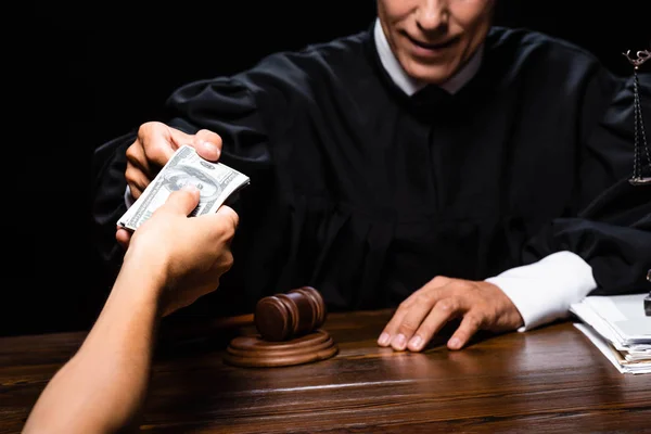 Corte vista de mulher dando suborno para julgar isolado em preto — Fotografia de Stock