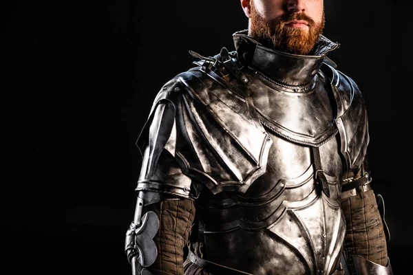 Vista cortada de cavaleiro em armadura isolada em preto — Fotografia de Stock