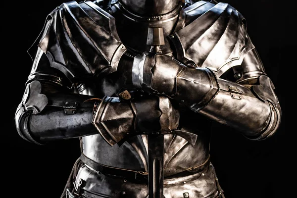 Vista cortada de cavaleiro em armadura segurando espada isolada em preto — Fotografia de Stock