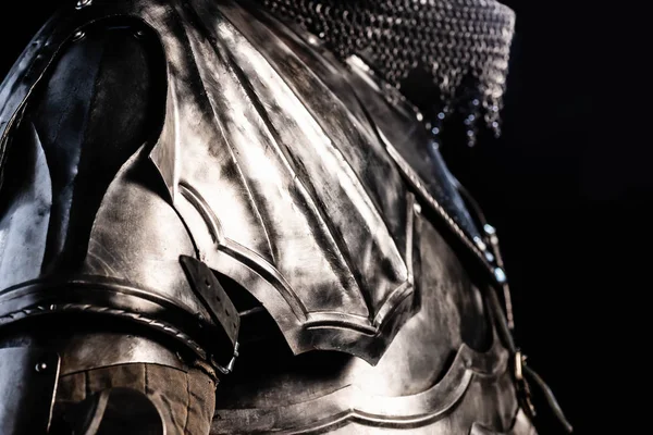 Cropped view of knight in armor holding sword isolated on black — Stock Photo