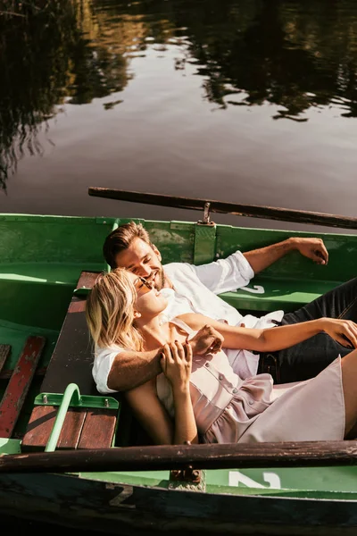 Heureux jeune couple regardant l'autre tout en étant assis dans le bateau — Photo de stock