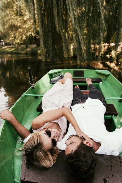 Visão aérea da jovem mulher tocando o rosto do namorado enquanto estava deitado no barco — Fotografia de Stock