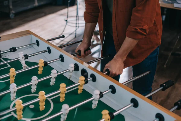 Ausgeschnittene Ansicht von Geschäftsmann, der im Büro Tischfußball spielt — Stockfoto