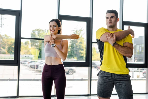 Deportista y deportista haciendo ejercicio juntos en el centro deportivo - foto de stock