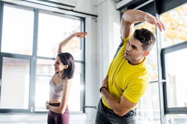 Sportsman and sportswoman working out together in sports center — Stock Photo