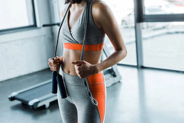 Cropped view of sportswoman with skipping rope in sports center — Stock Photo