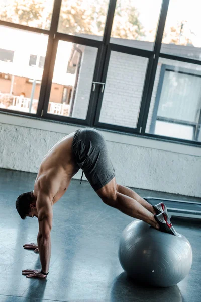 Handsome sportsman working out on fitness ball in sports center — Stock Photo