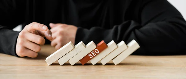 Plan panoramique de seo manager pointant du doigt les rectangles en bois avec lettrage seo — Photo de stock