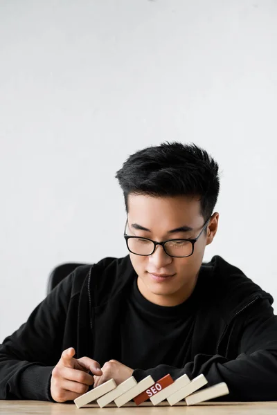 Менеджер Seo, играющий с деревянными прямоугольниками при помощи Leo Seo — стоковое фото