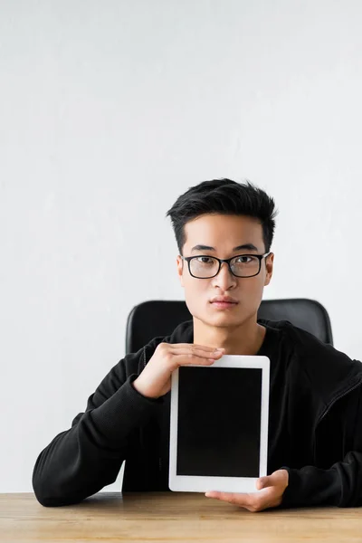 Asian hacker holding digital tablet with copy space — Stock Photo