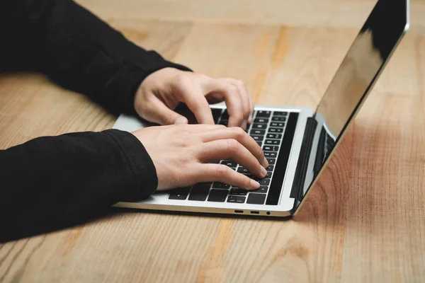 Vue recadrée du pirate à l'aide d'un ordinateur portable et assis à table — Photo de stock