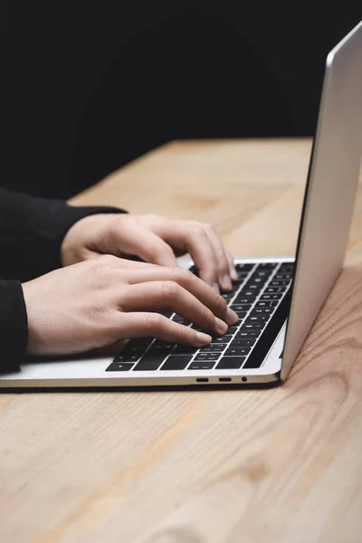 Abgeschnittene Ansicht von Hackern, die Laptop benutzen und am Tisch sitzen — Stockfoto