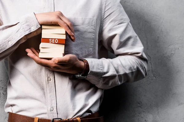 Cropped view of seo manager holding wooden rectangles with lettering seo — Stock Photo