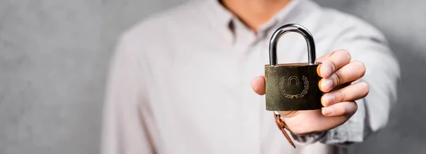 Panoramic shot of seo manager holding metal padlock in office — Stock Photo