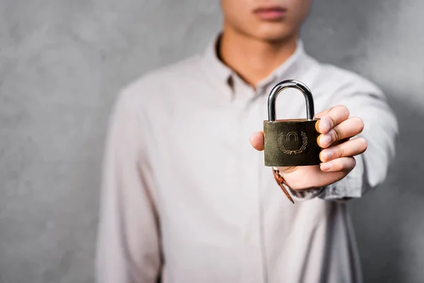 Vue recadrée du directeur de SEO tenant cadenas en métal dans le bureau — Photo de stock