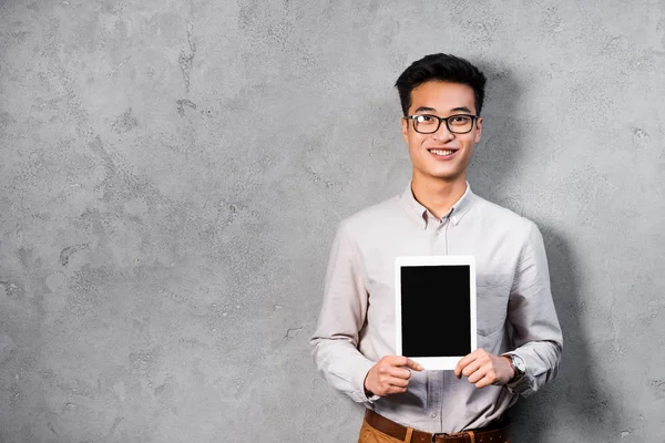 Улыбающийся азиатский SEO менеджер держит цифровой планшет с копировальным пространством — стоковое фото