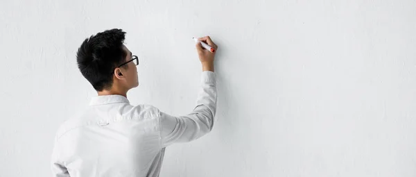 Панорамний знімок сео-менеджера, що пише на білій стіні — стокове фото