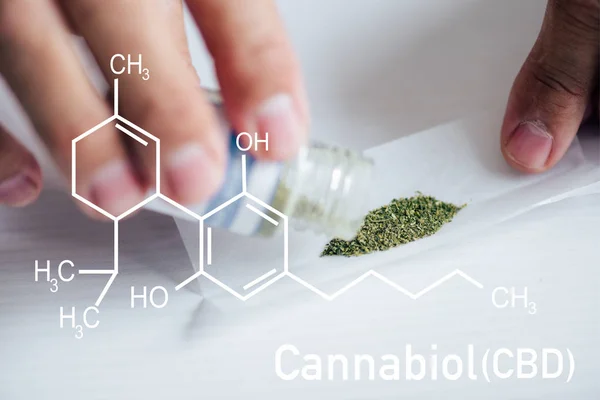 Vista recortada del hombre haciendo articulación de cannabis medicinal con ilustración de moléculas de cbd - foto de stock