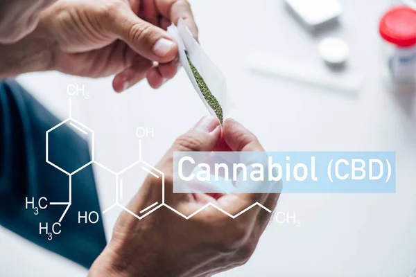 Abgeschnittene Ansicht eines Mannes, der stumpfen medizinischen Cannabis mit cbd-Molekül in der Hand hält — Stockfoto